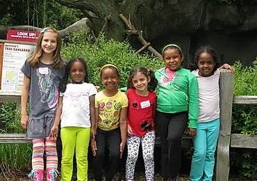 Six children standing in a row outdoors