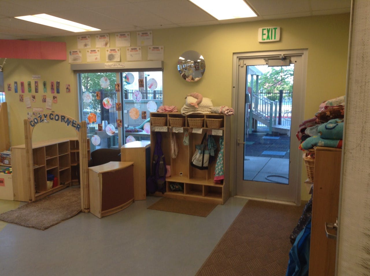 Classroom interior with "Cozy Corner" sign, storage cubbies, and exit door to playground