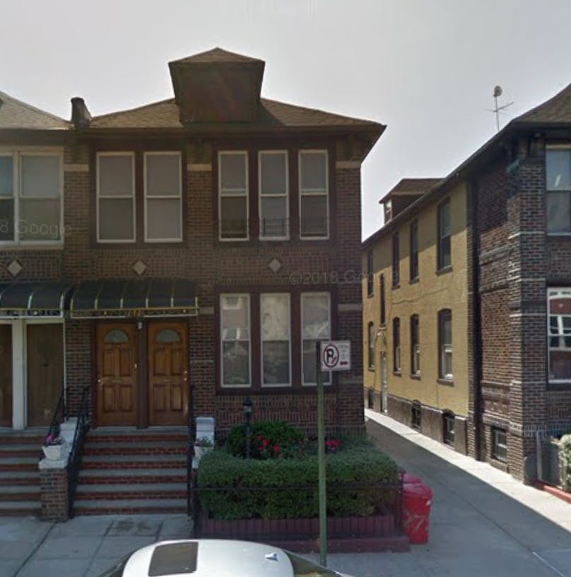Brick building with two wooden doors and a small awning