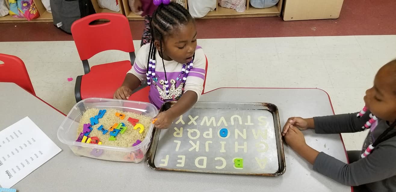 Child playing with alphabet letters in a classroom