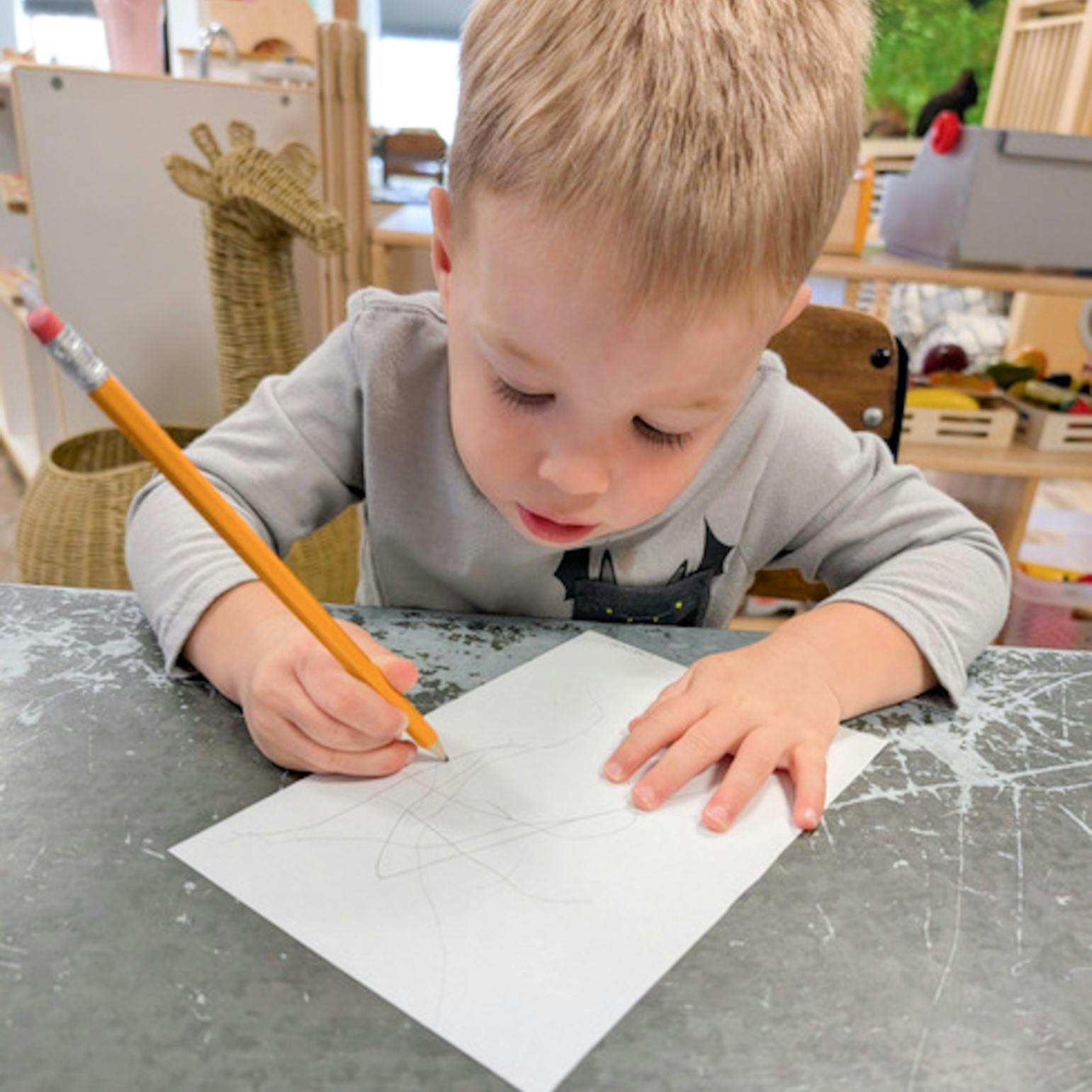 Child drawing on paper with a pencil