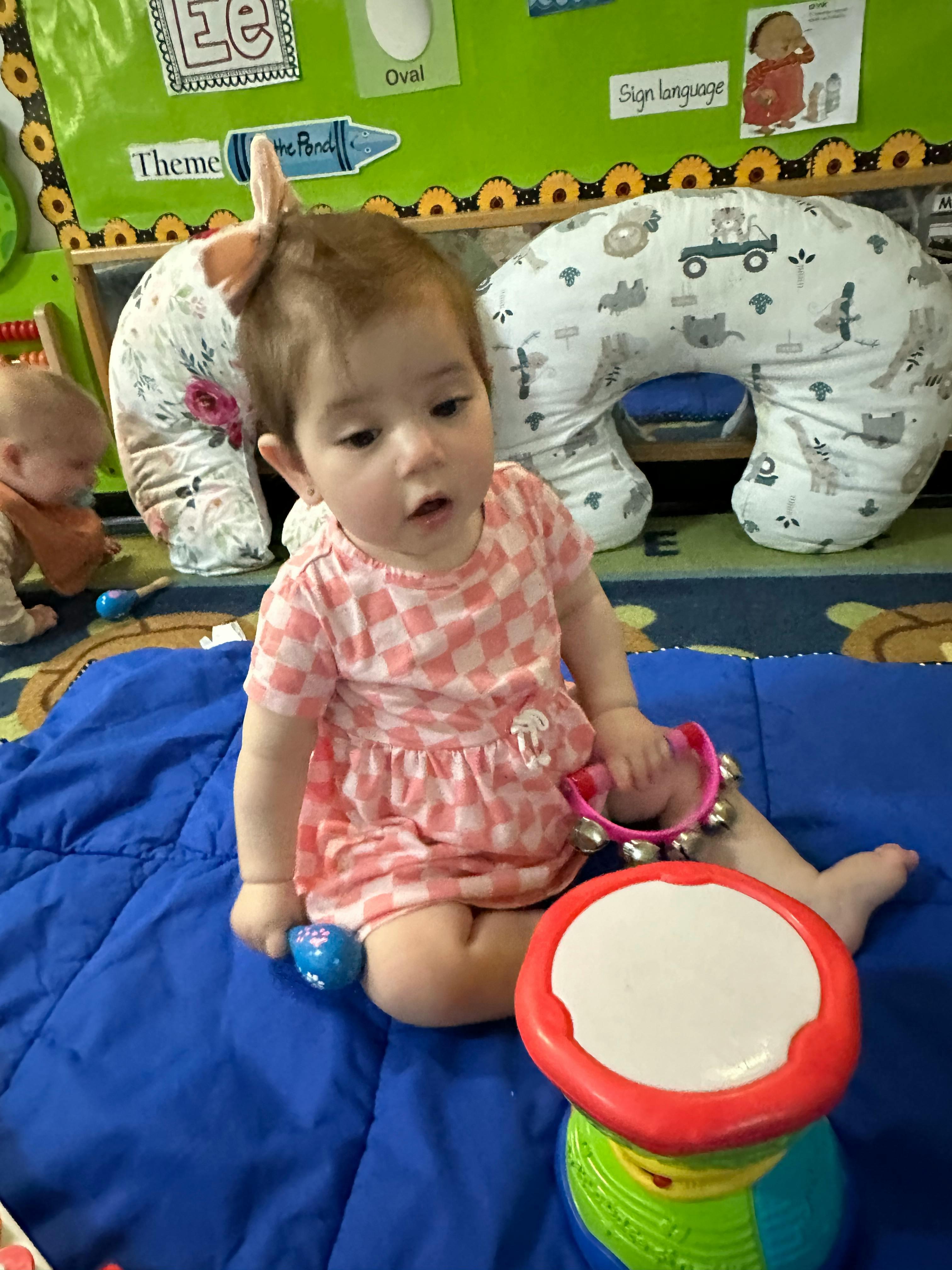 Child sitting on a blue blanket with musical toys