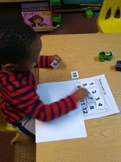Child doing a number matching activity at a table