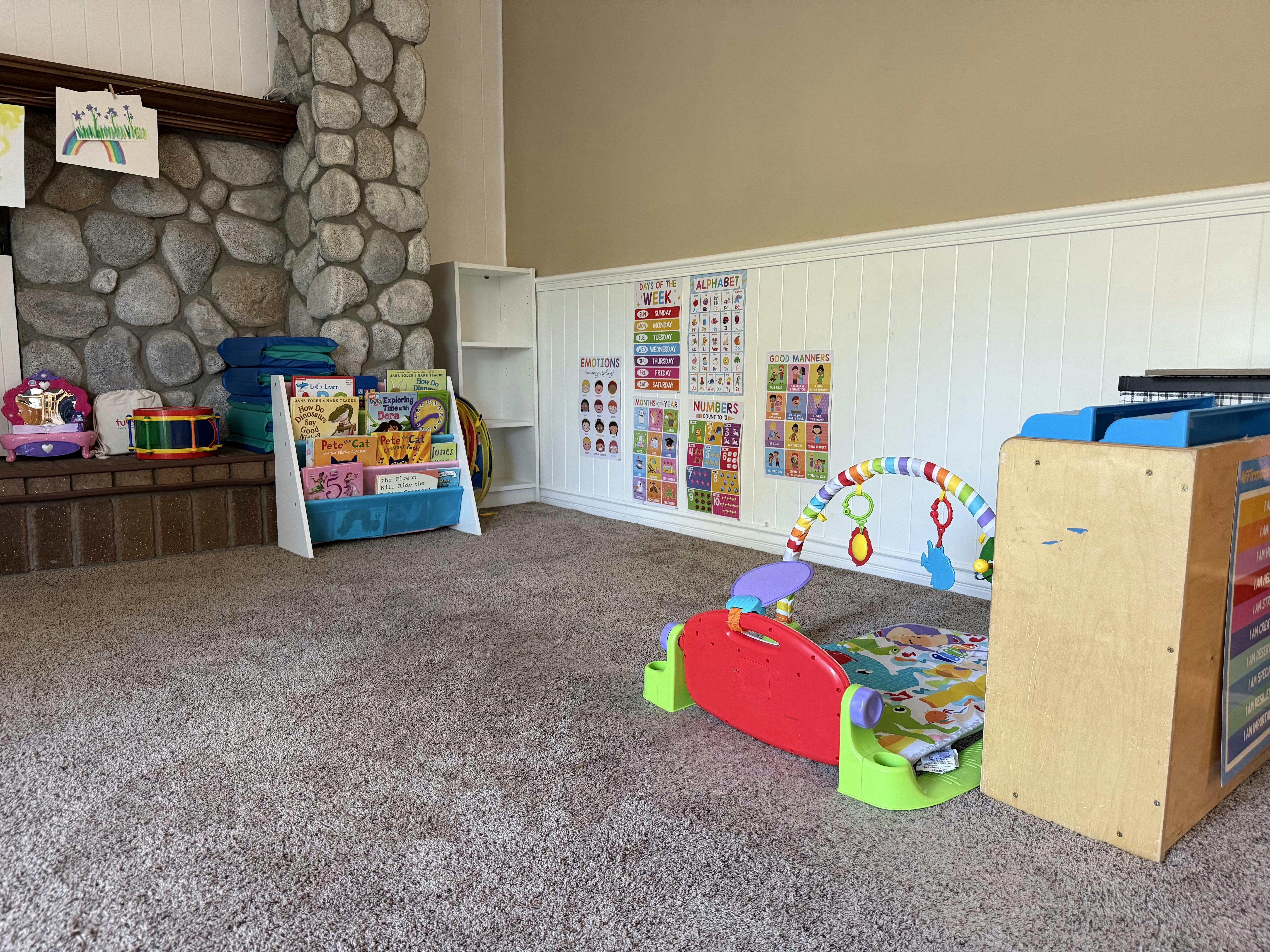 Children's play area with toys, books, and educational posters