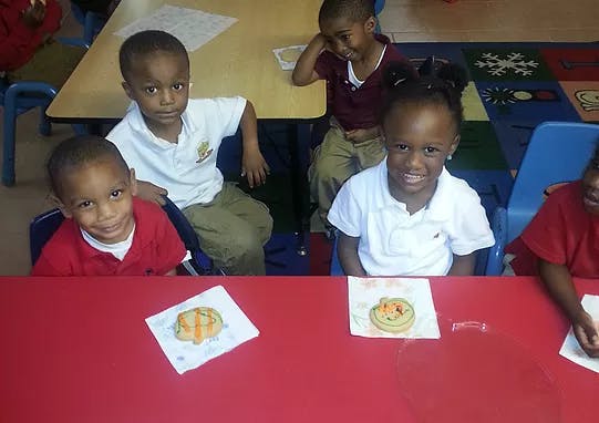 Children sitting at tables in a classroom