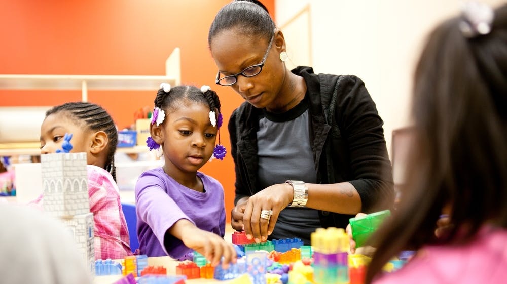 Adult and child playing with colorful blocks