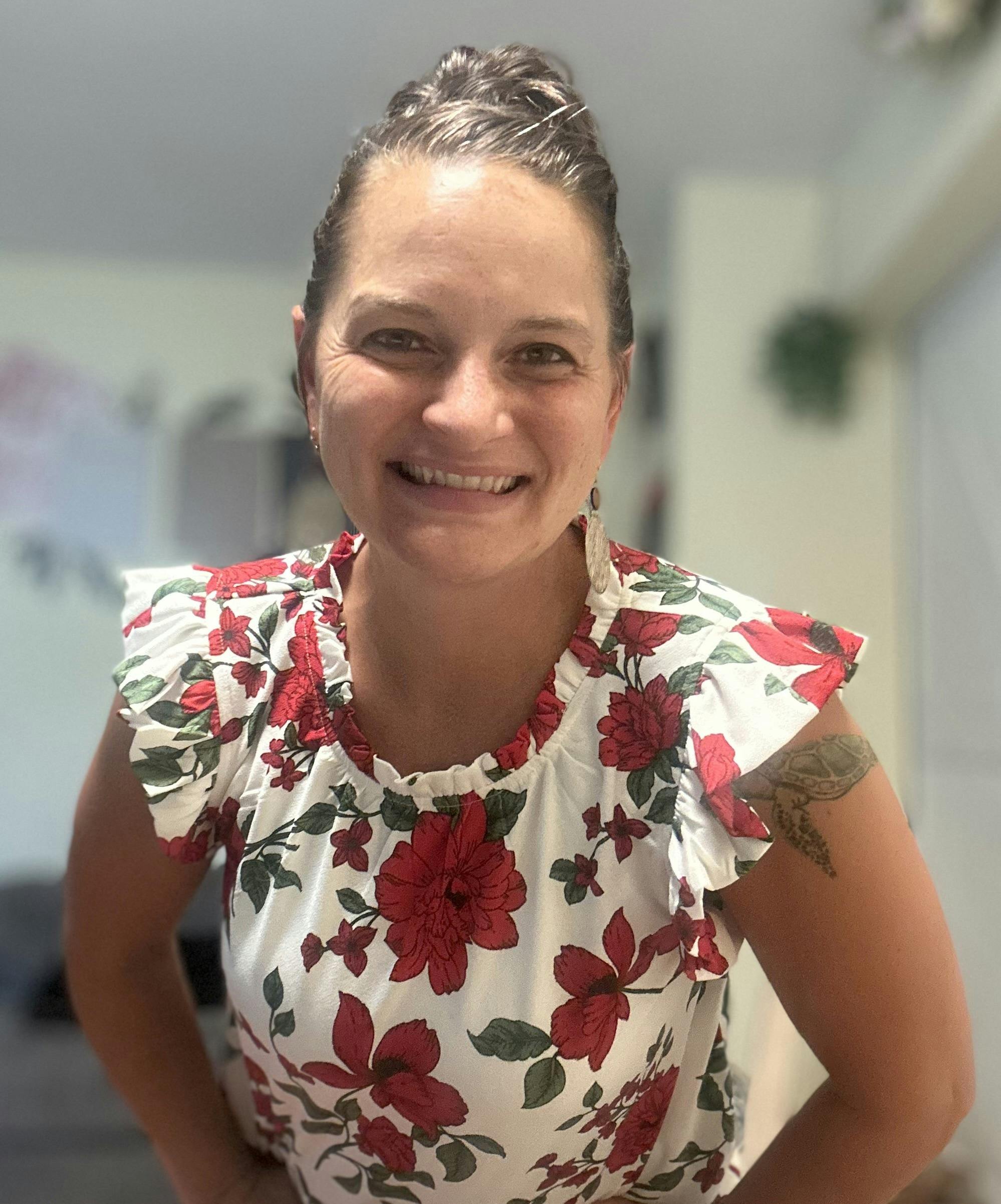 A person with hair in an updo wearing a floral top