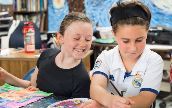 Two children painting at a table