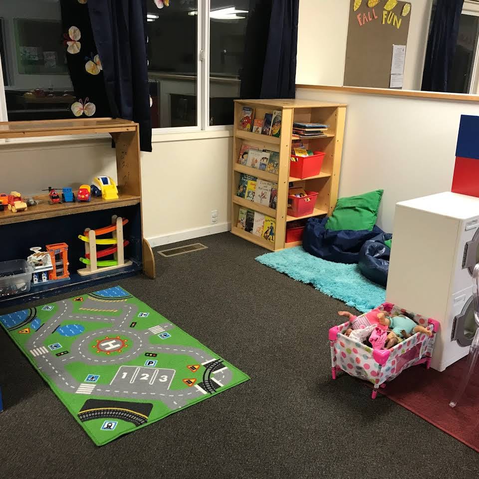 Playroom with toy shelves, play mat, and doll crib