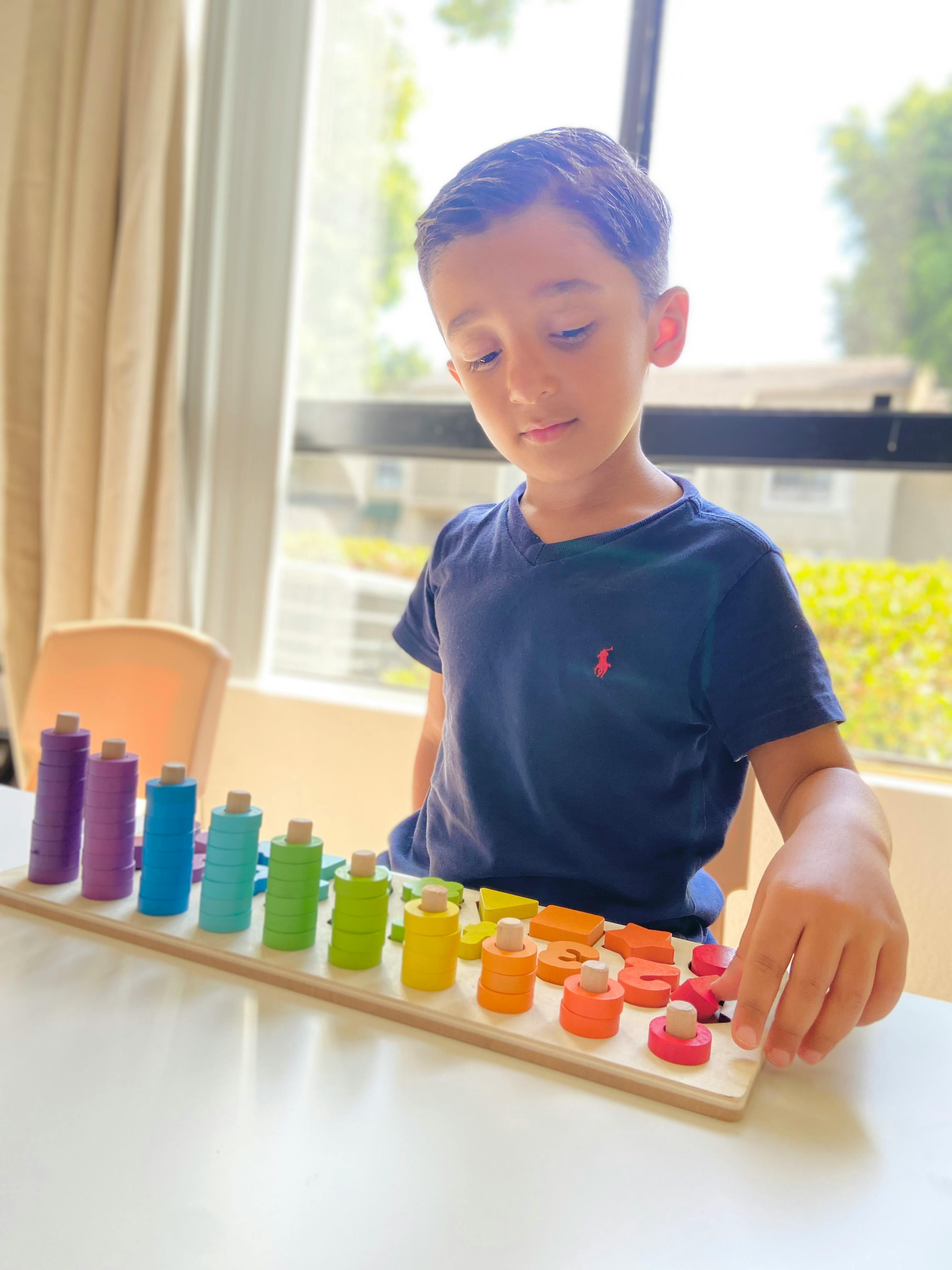 Child playing with a colorful wooden sorting toy