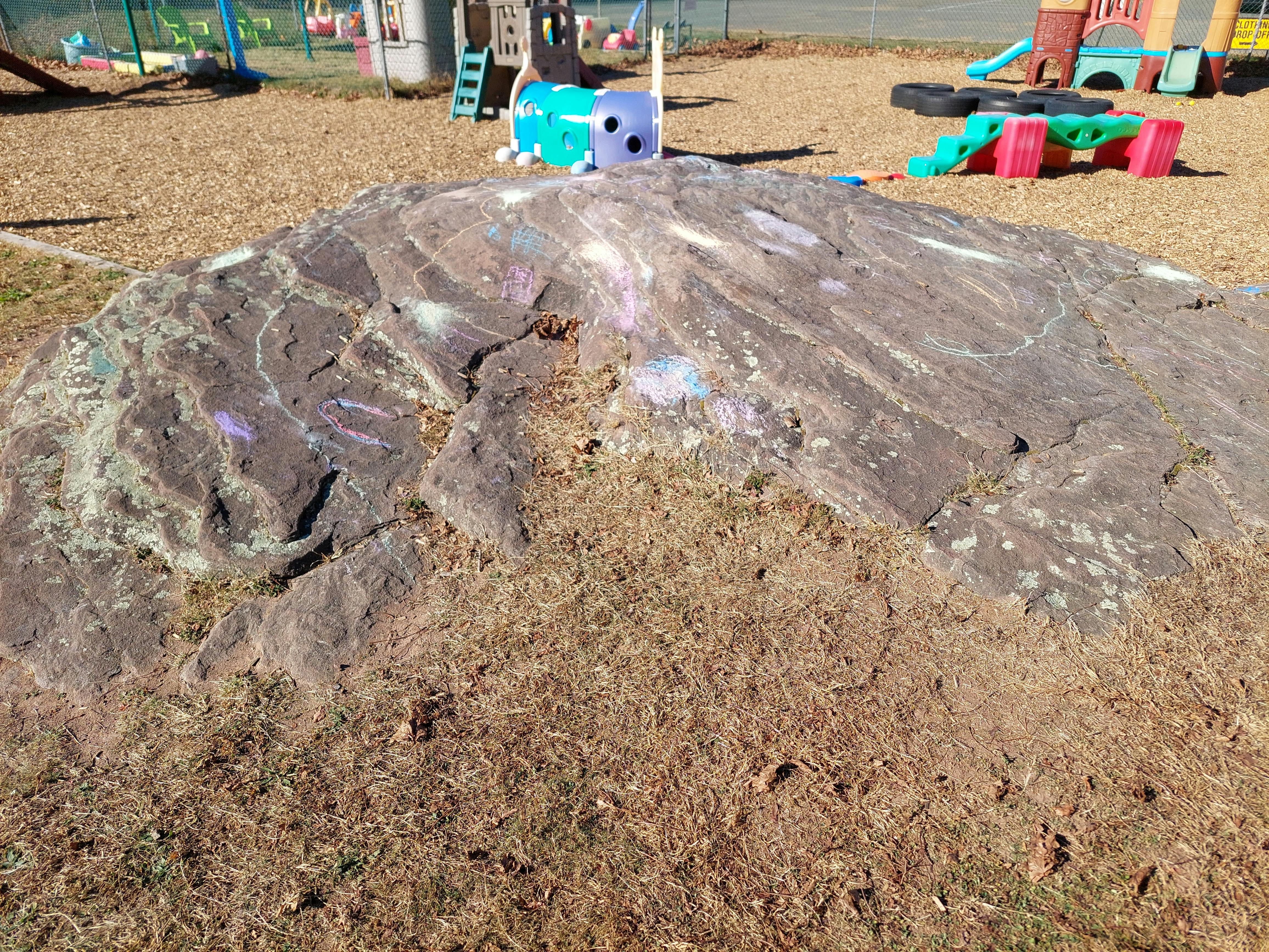 Rock with chalk drawings on a playground