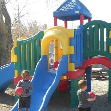 Two children holding balls on a playground