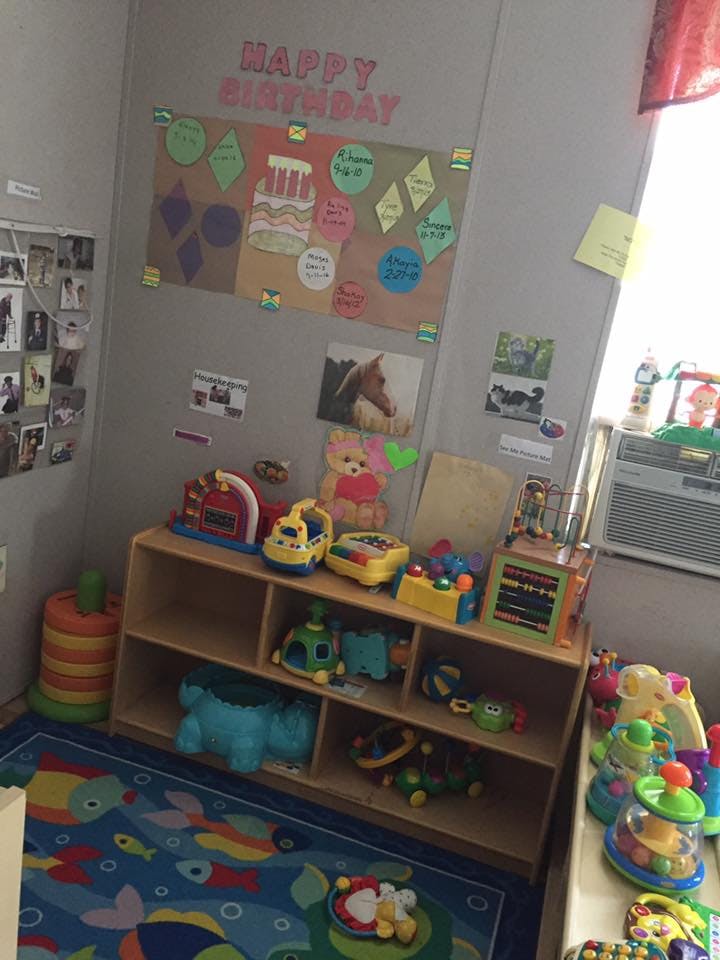Playroom with a wooden shelf filled with toys and a colorful rug