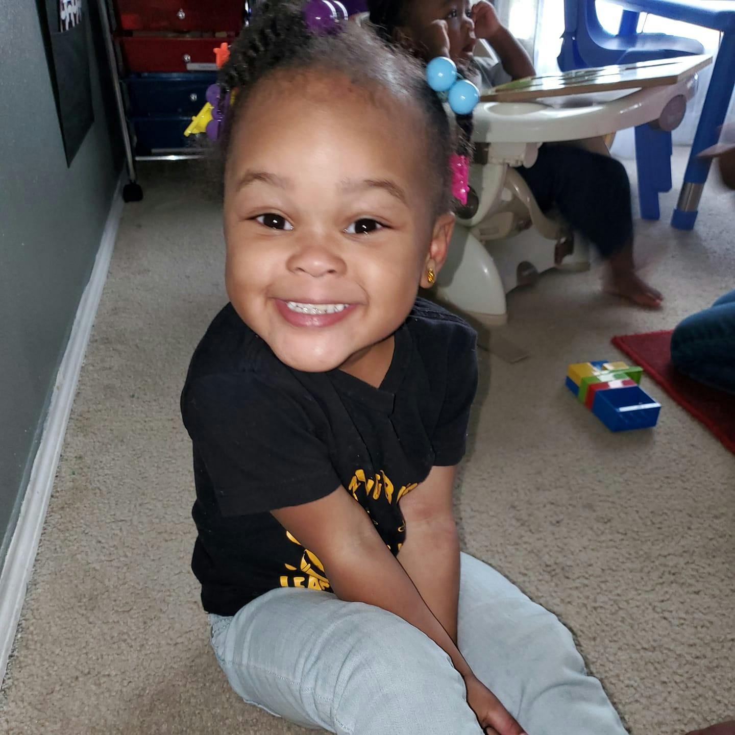 Child sitting on the floor smiling