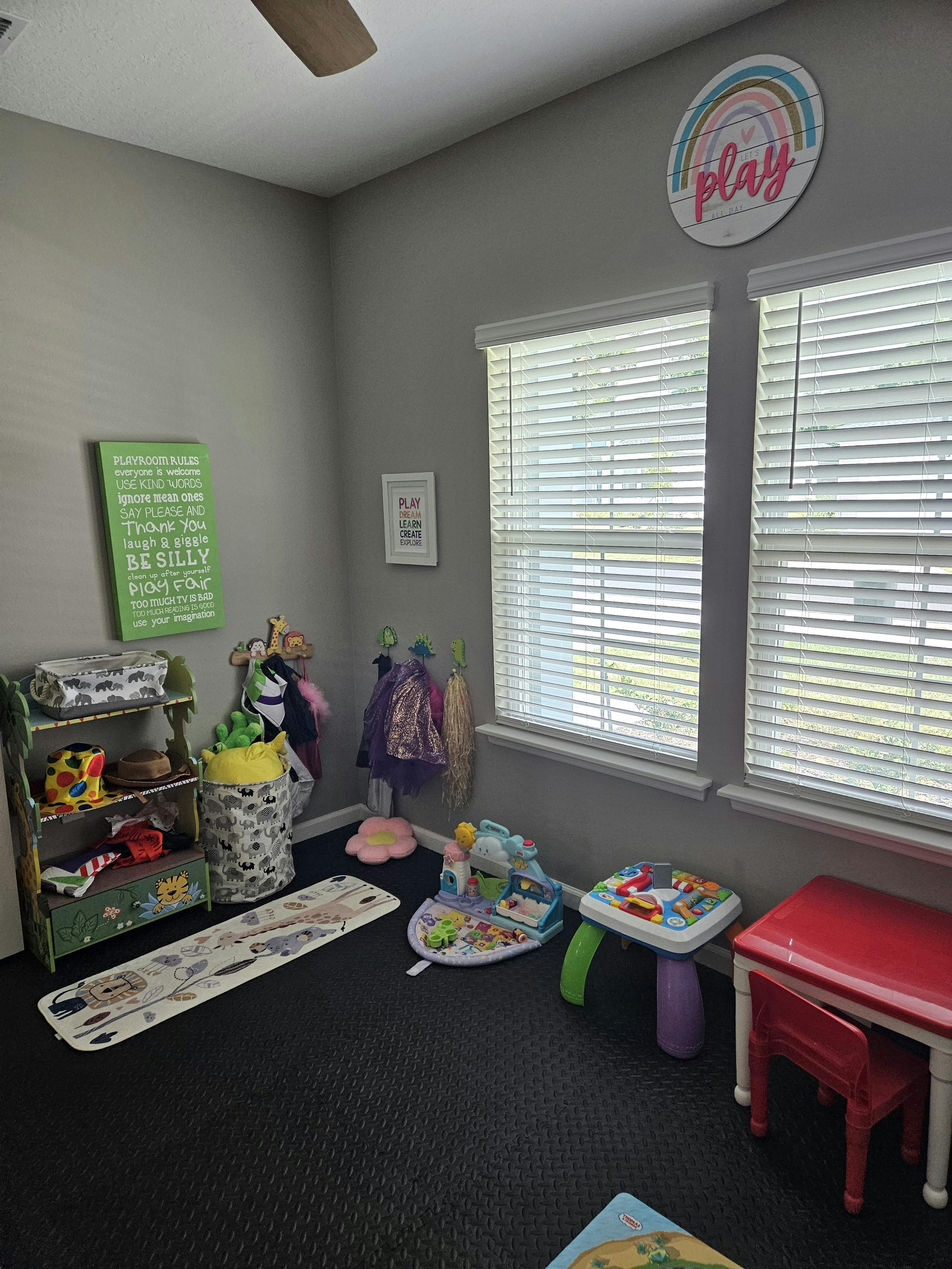 Children's play area with toys, shelves, and a small table and chair