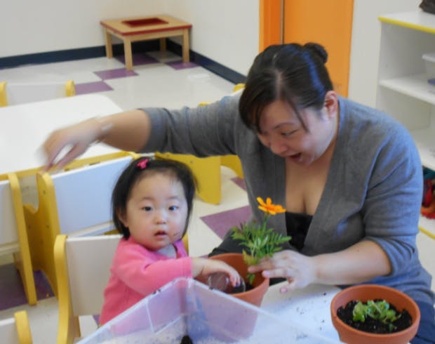 Adult and child planting a flower in a pot
