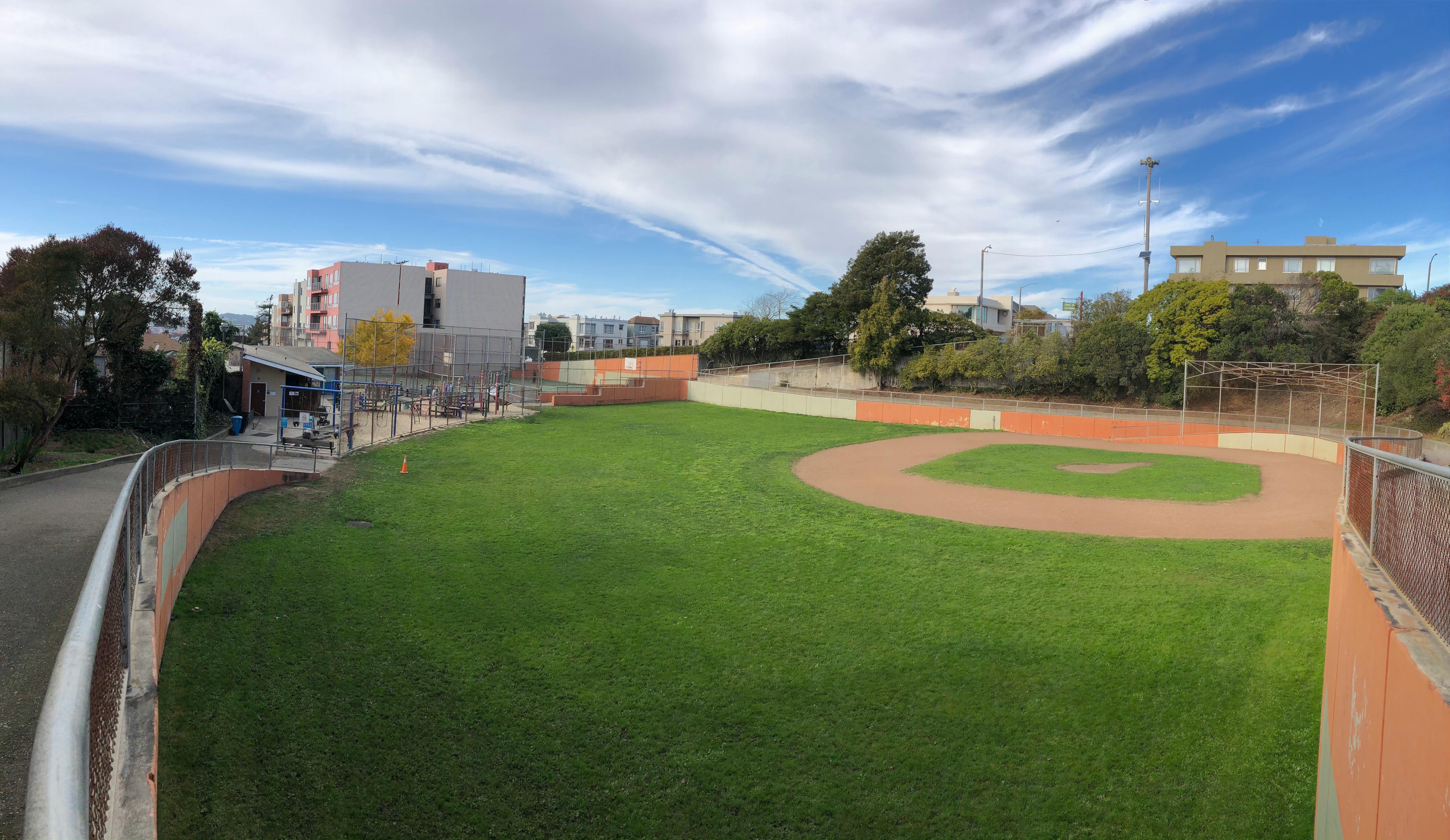 Empty baseball field with green grass and dirt infield
