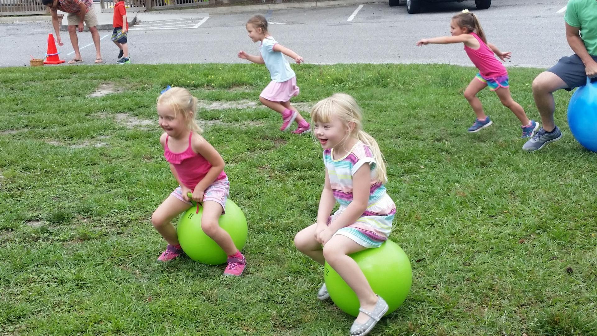 Children playing with bouncy balls on grass