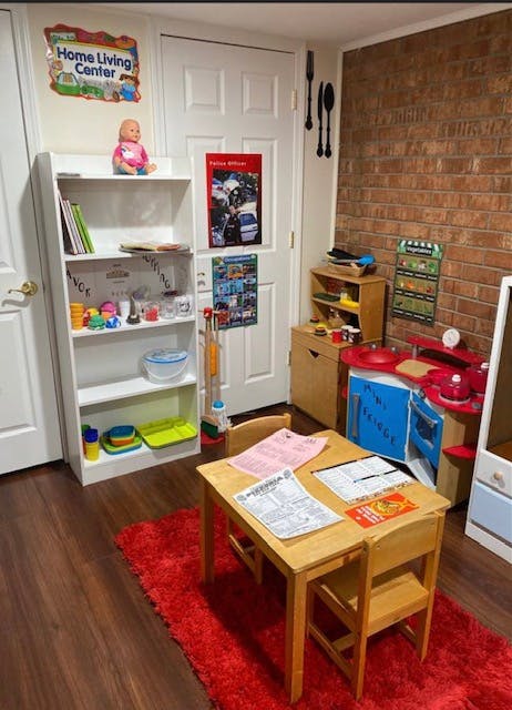 Playroom with a small table and chairs, toy kitchen, and bookshelf