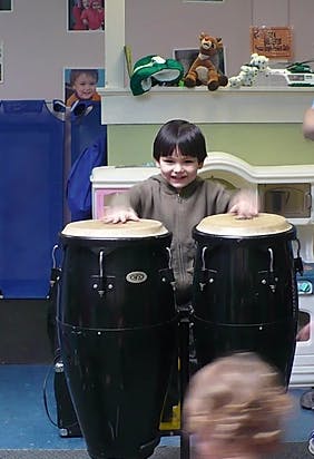 Child playing two large drums