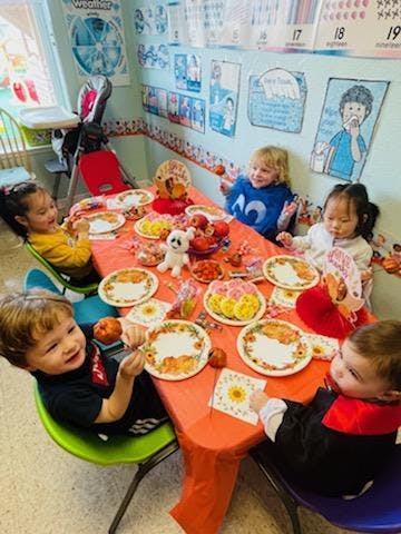 Children sitting around a table with plates and snacks