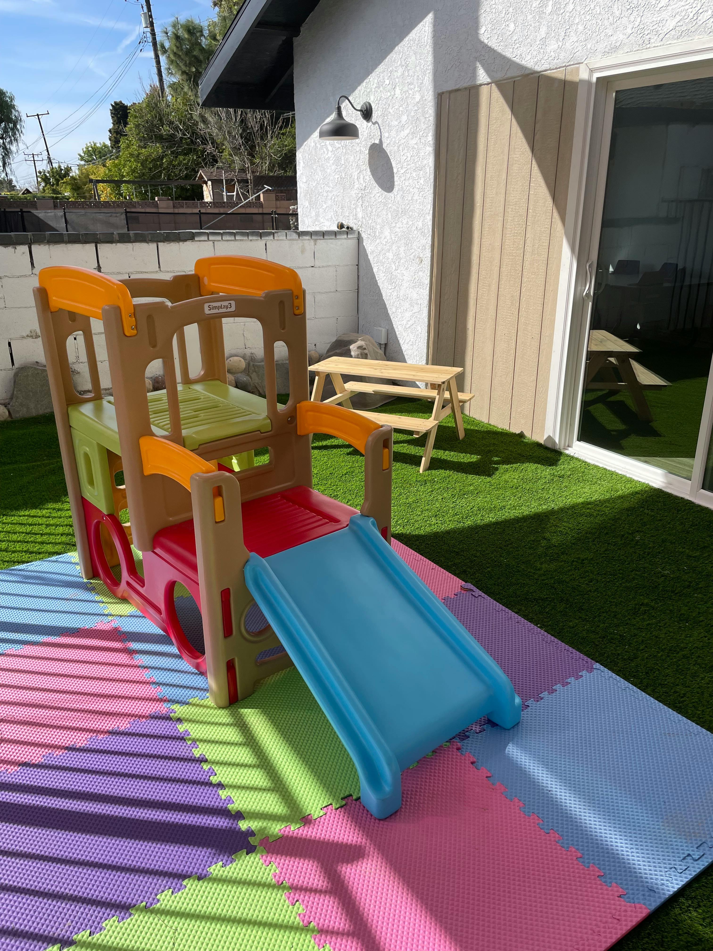 Child's play structure with slide on colorful foam mats