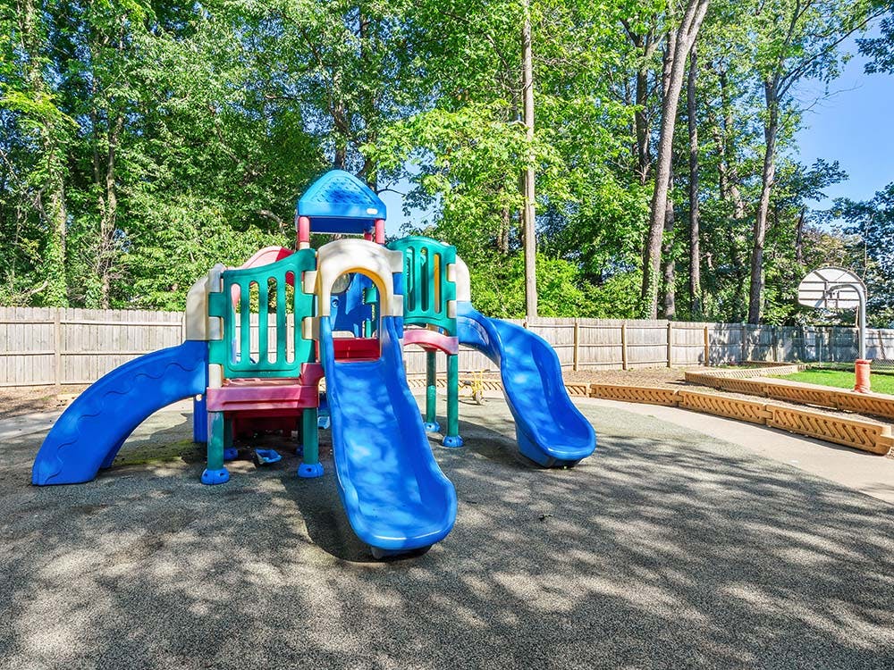 Colorful playground structure with slides on a padded surface