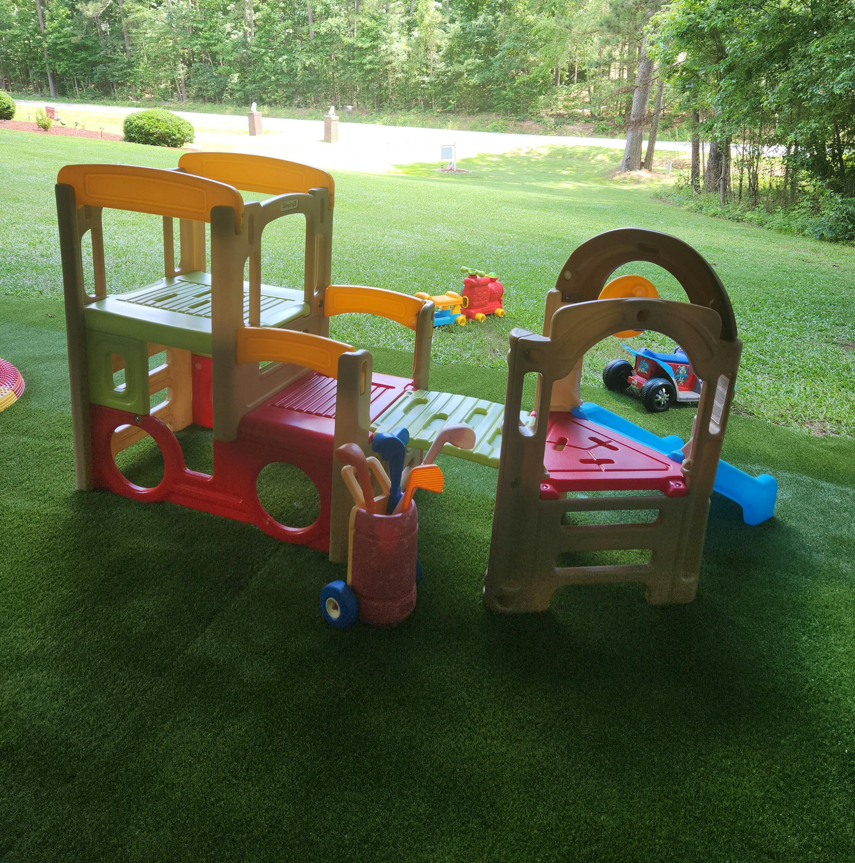 Colorful plastic outdoor play structure with slide and toy golf clubs