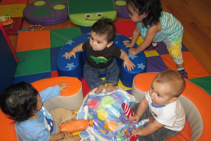 Four children playing on soft play equipment