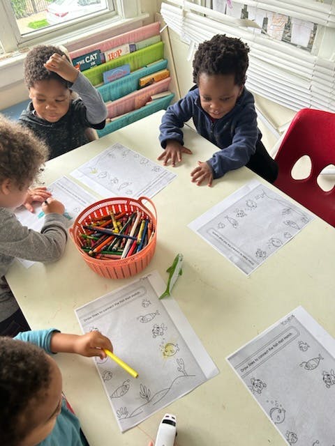 Children coloring at a table with crayons