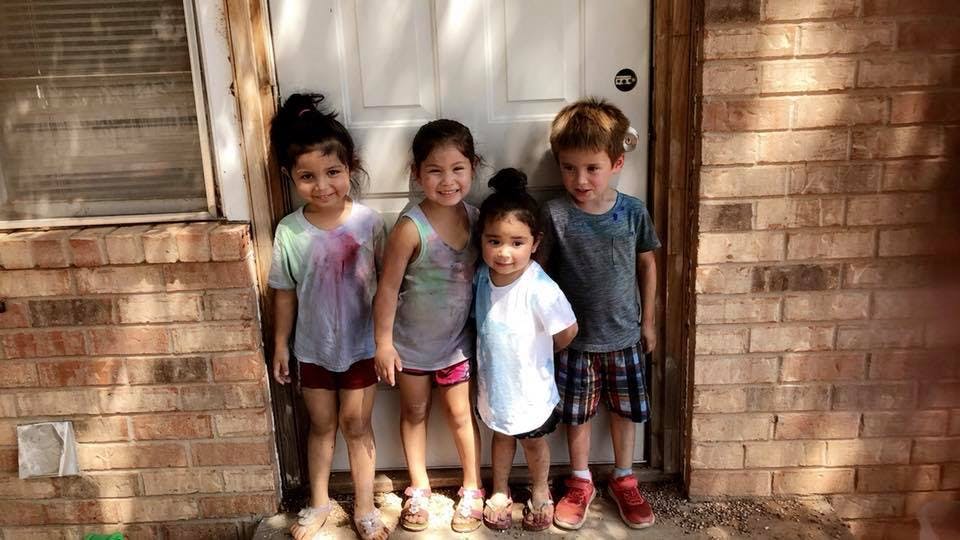Four children standing in front of a door