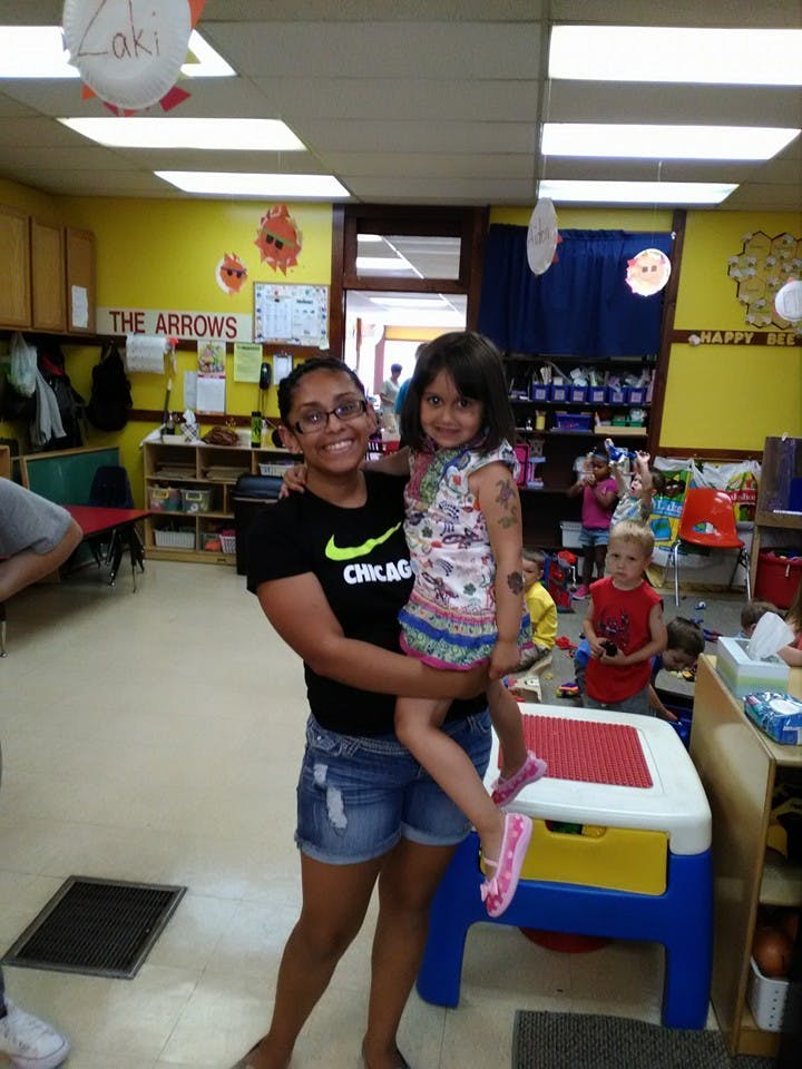 Person holding a child in a classroom