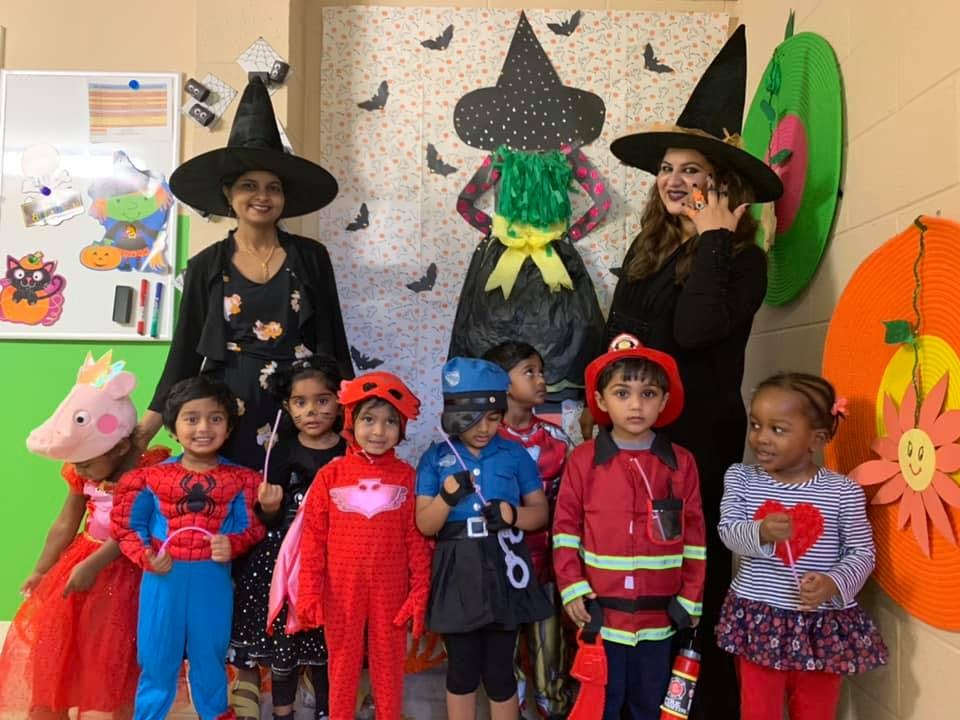 Two people in witch hats with children in costumes