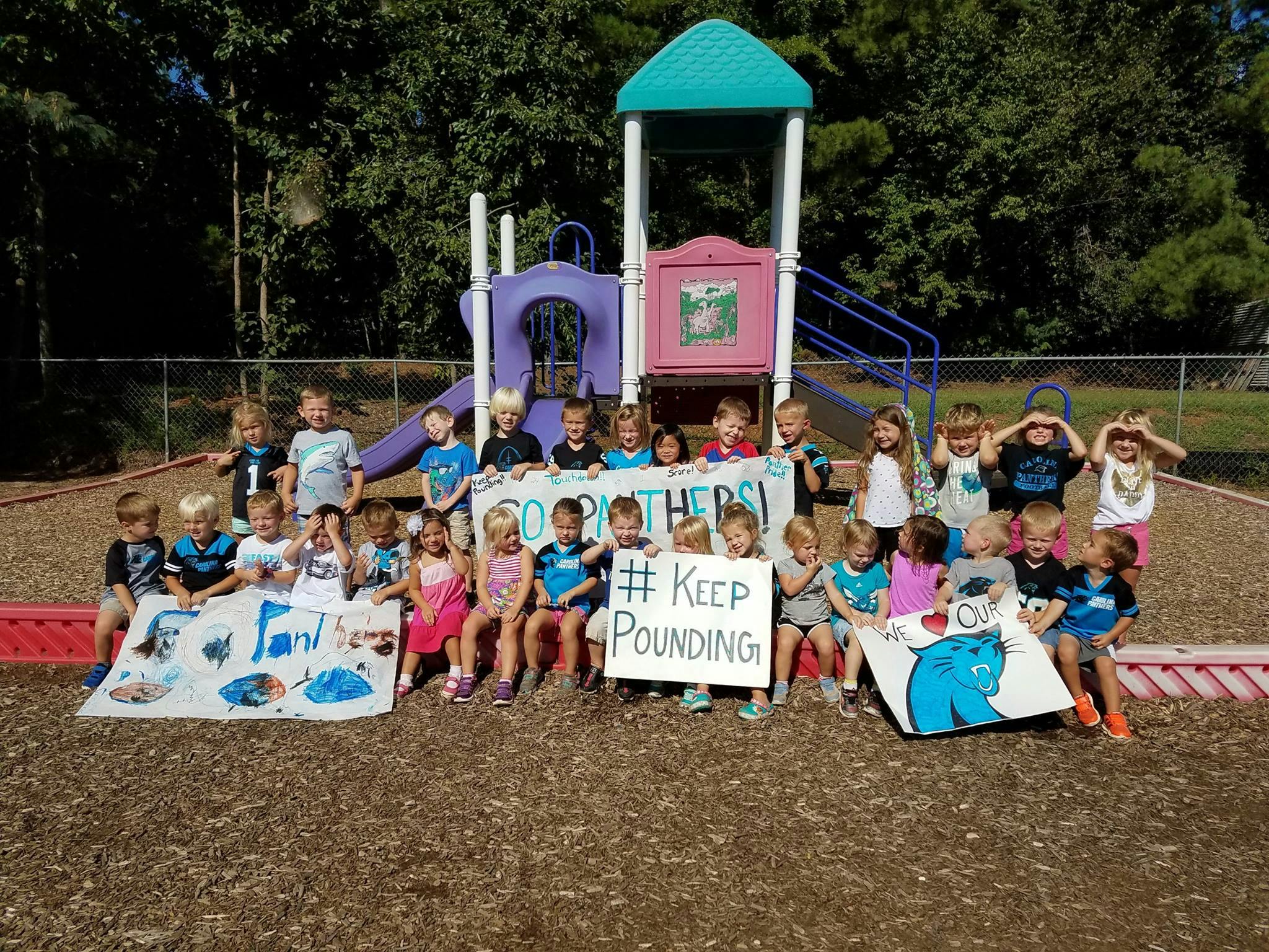 Group of children holding signs on a playground
