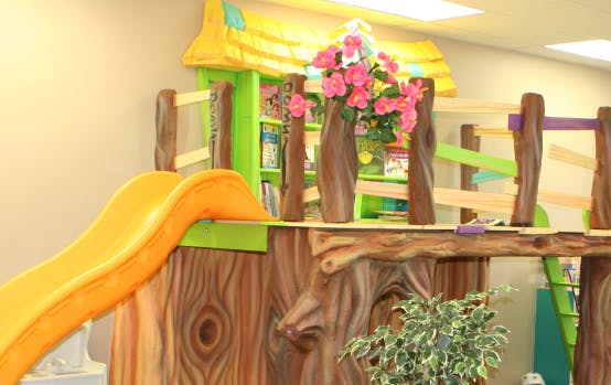 Play structure with a slide and a vase of flowers