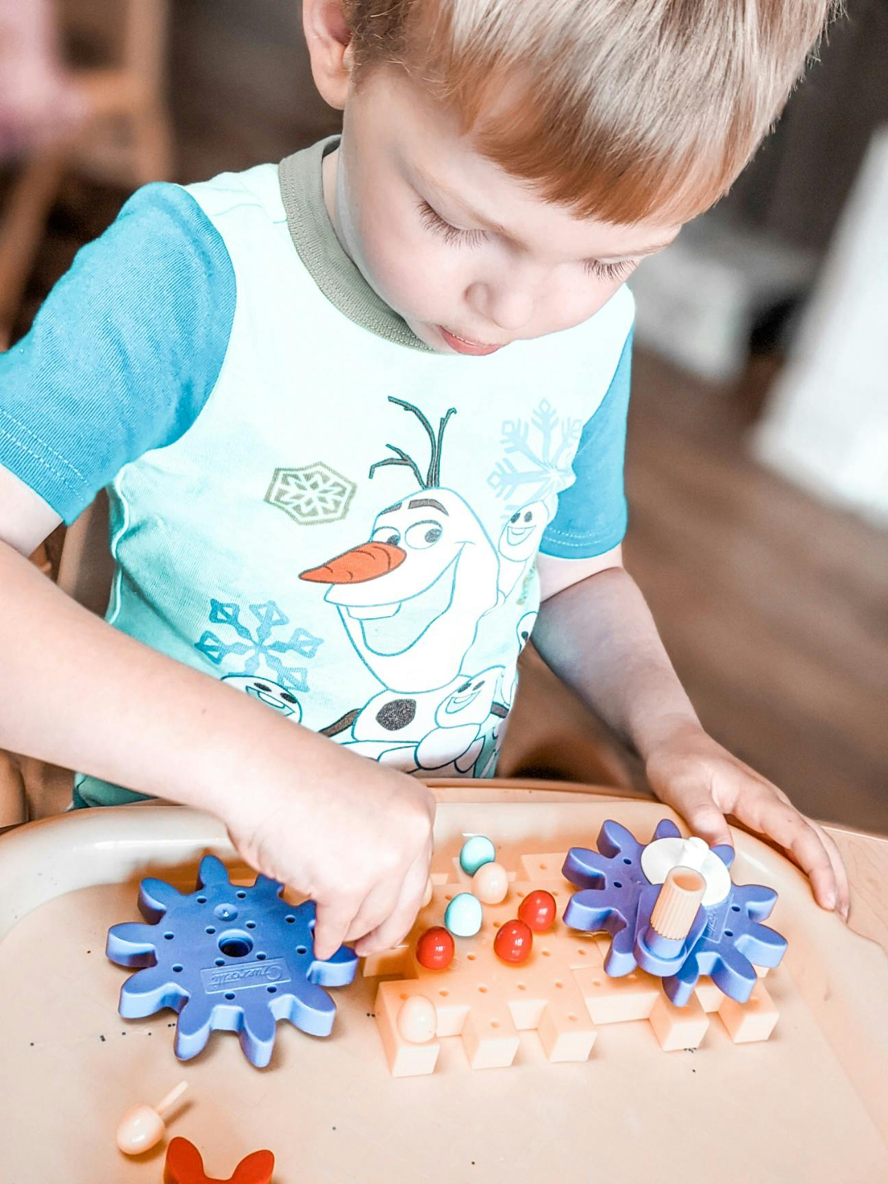 Child playing with a pegboard and colorful pegs