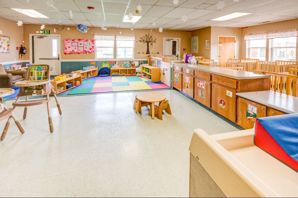 Empty classroom with colorful rug and small tables