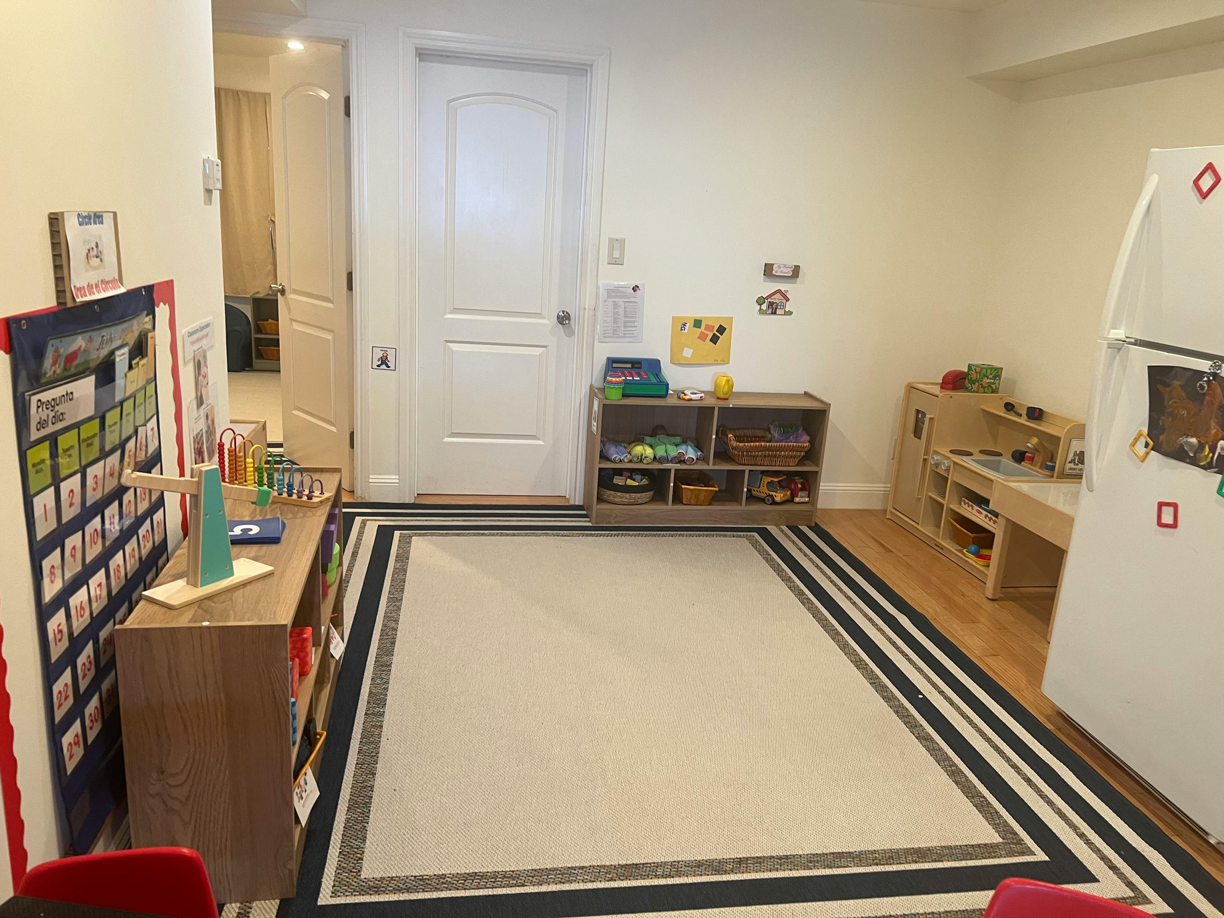 Playroom with a rug, shelves, and a small table