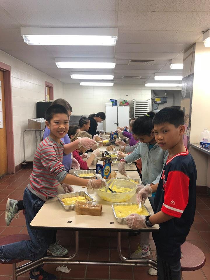 Children in a kitchen preparing food in aluminum pans