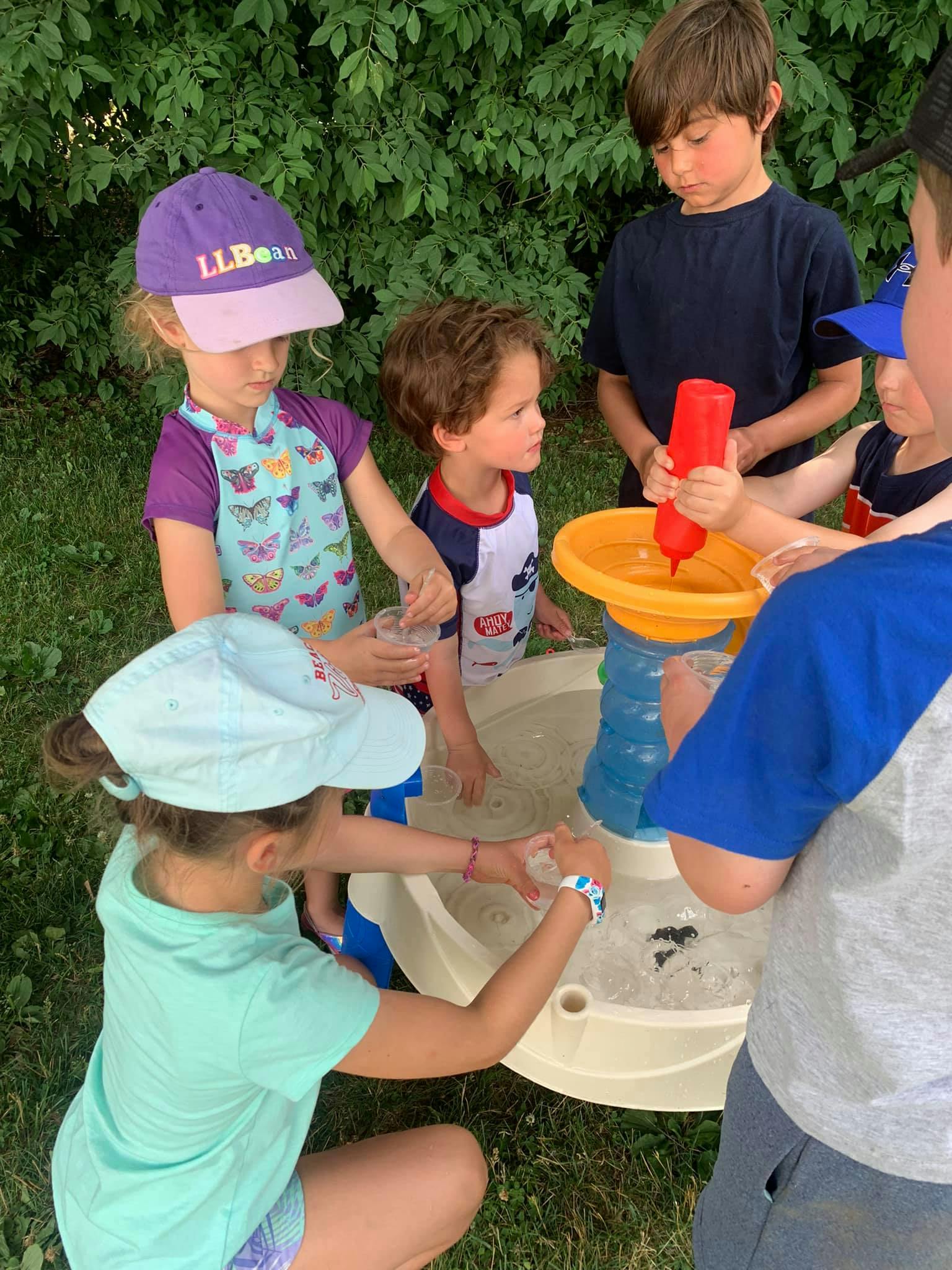 Children playing with a water table outdoors