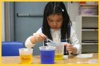 Child doing a science experiment with colored liquids