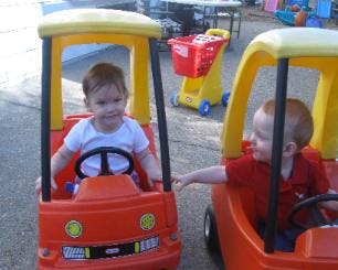 Two children in toy cars