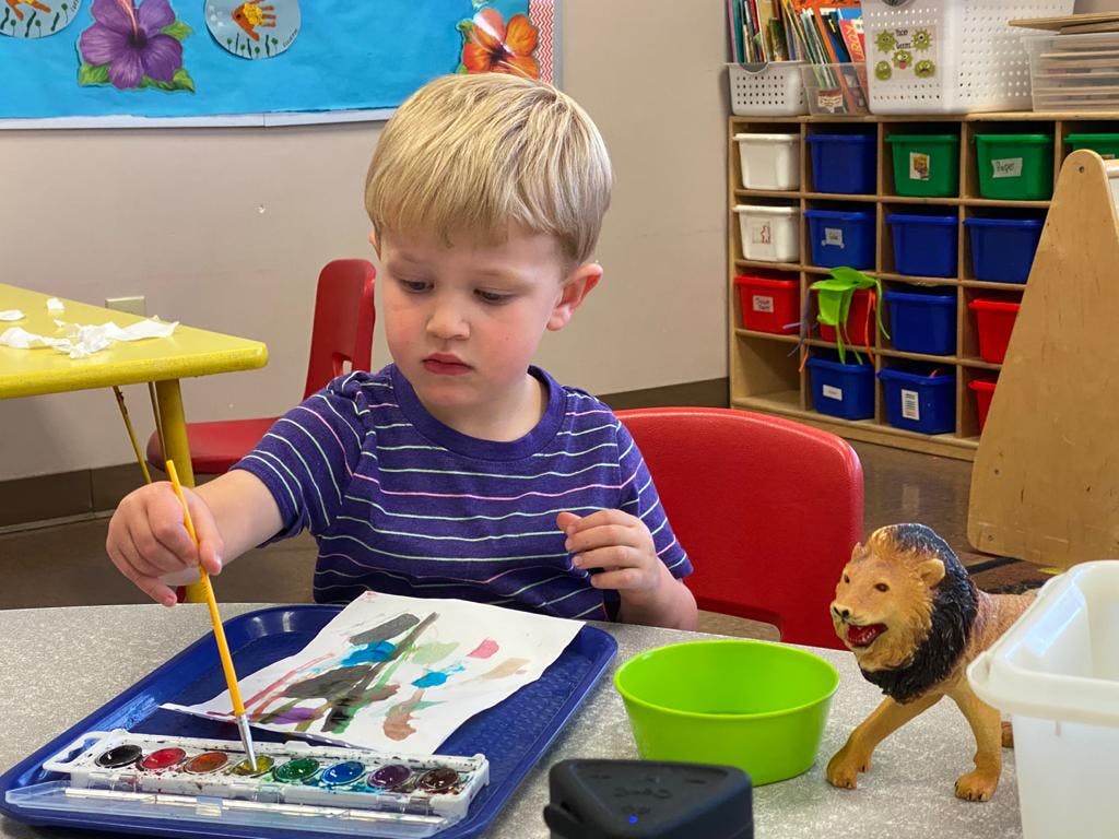 Child painting with watercolors at a table
