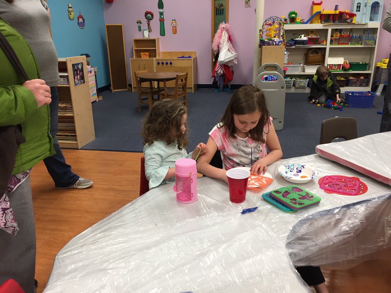 Two children sitting at a table doing an art activity