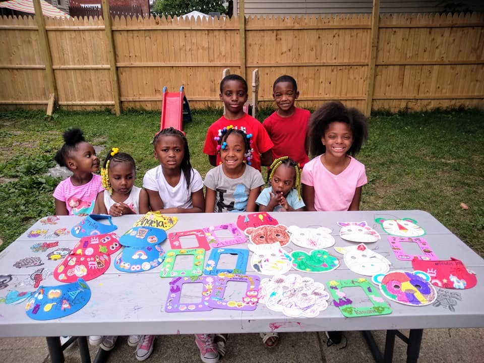 Group of children standing behind a table with crafts