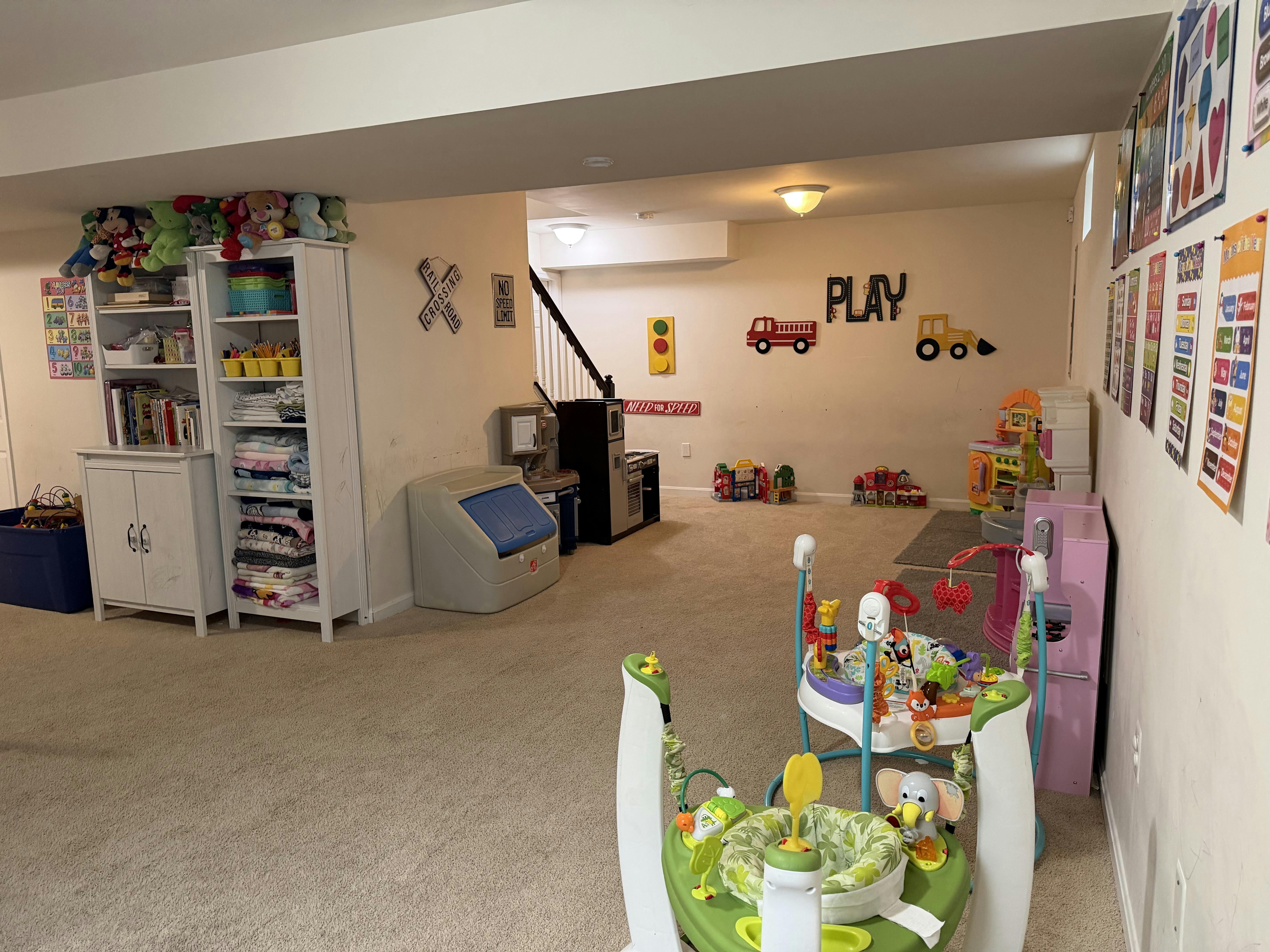 Playroom with toys, shelves, and learning charts on the walls