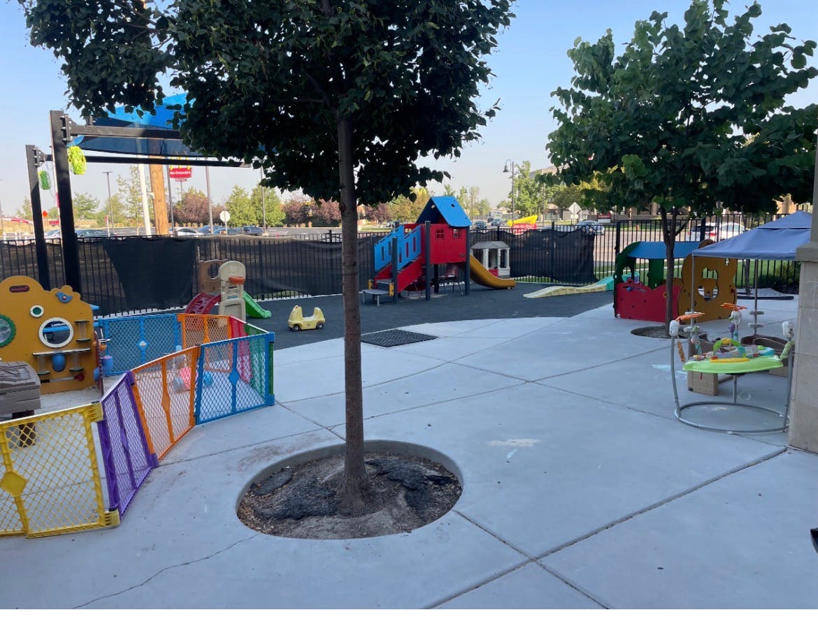 An outdoor playground with various colorful play structures and fences