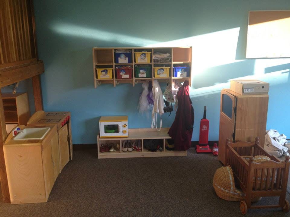 Classroom with cubbies, coat hooks, and play furniture