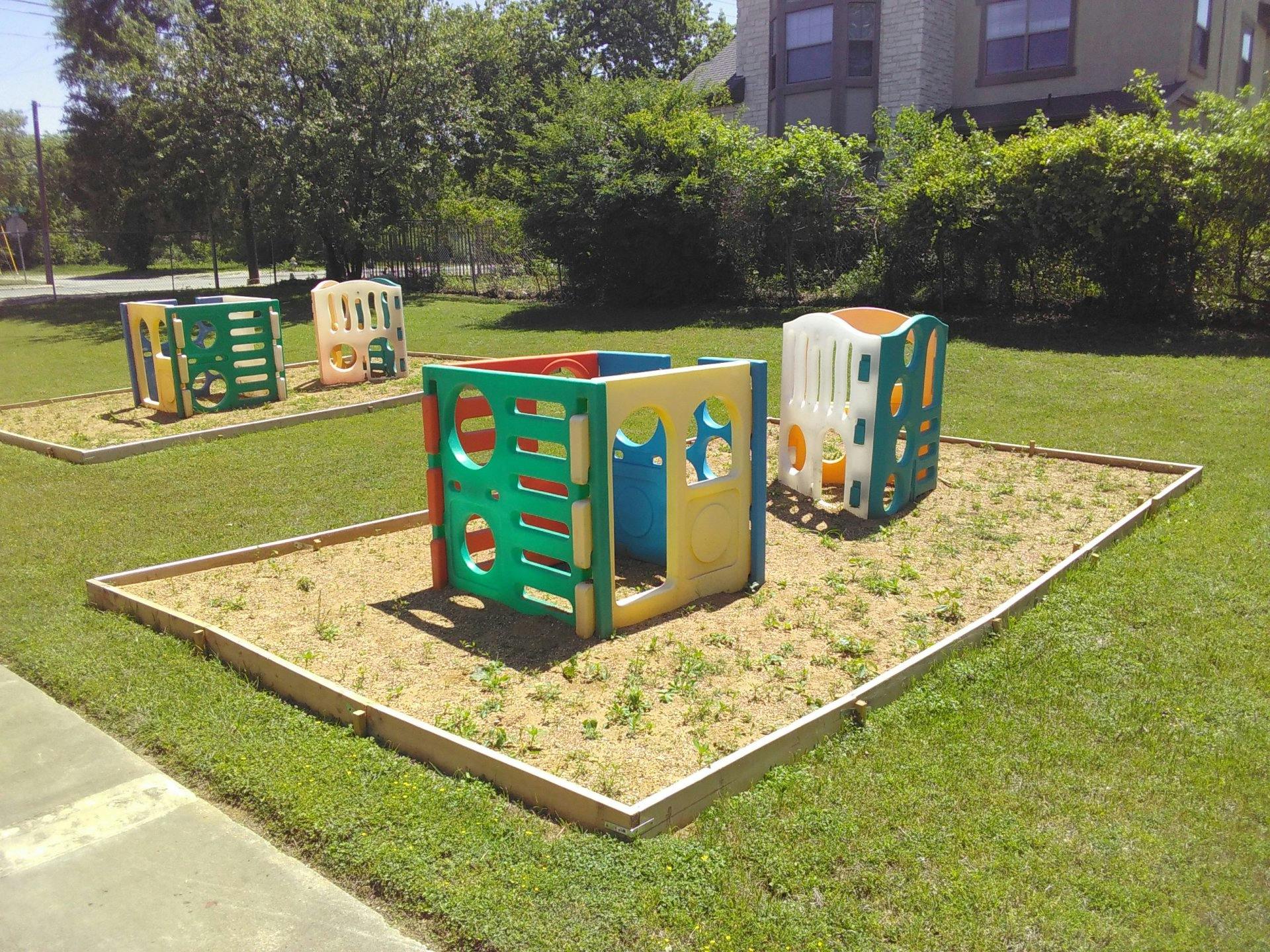 Playground with colorful plastic playhouses in sandboxes