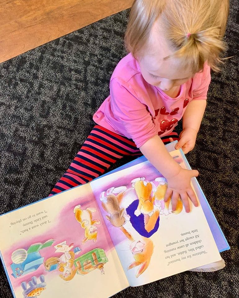 Child looking at an open book with illustrations